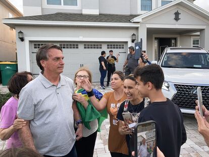 El expresidente de Brasil Jair Bolsonaro posa con admiradores en el exterior del chalet prestado donde se aloja en Florida
