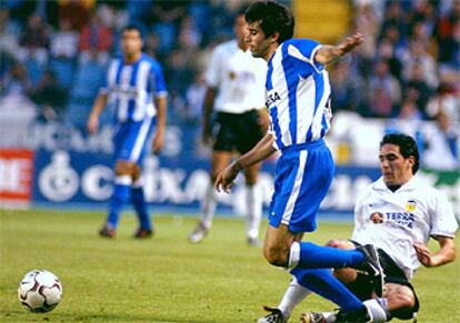 El centrocampista del Deportivo de la Coruña, Valerón, escapa con el balón controlado de la presión del jugador del Valencia Vicente.