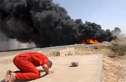 Un bombero iraquí interrumpe su lucha contra las llamas en un oleoducto para efectuar la oración del mediodía, ayer, cerca de la localidad de Baiyi (Irak).