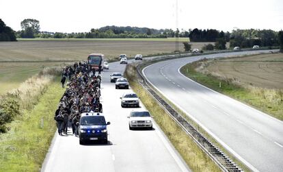 El primer ministro de Dinamarca, Lars Lokke Rasmussen, ha advertido este lunes de que imponer controles en la frontera con Alemania no servirá para solucionar la crisis de refugiados, después de que durante el fin de semana hayan llegado a territorio danés más de 400 personas. En la imagen, un grupo de refugiados son escoltados por la policía por una carretera de Dinamarca, el 7 de septiembre de 2015.