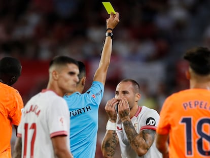 El arbitro del encuentro saca amarilla a Gudelj durante el partido de liga ante el Valencia en el Sánchez Pizjuan.