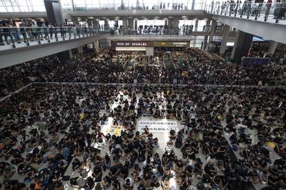 Manifestantes participan en una "sentada" en el aeropuerto de Hong Kong, el 12 de agosto de 2019. Con pancartas en las que se leía "¡Aquellos que van a la calle hoy son valientes!" y "¡Liberen a todos los detenidos!", la protesta de este lunes obligó a las autoridades a suspender todos los vuelos en la terminal.