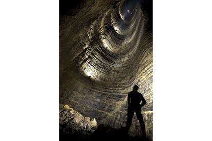 Uno de los pozos naturales más hondos que se conocen es el de las cavernas de Miao Keng, en el pueblo de Tian Xing, en el centro de China. A 519 metros de profundidad, el fotógrafo británico Robert Shone, tras dos horas de descenso en rápel, se autorretrata mirando hacia otros espeleólogos que bajan e iluminan las paredes de la sima. Este túnel vertical conecta con otra cueva aún más profunda, hasta 1.026 metros bajo tierra.