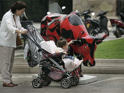 Una niña acaricia a una de las vacas de la avenida de Pau Casals de Barcelona.