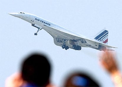 Dos personas despiden al avión supersónico en su despegue de esta mañana en París.