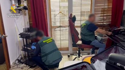 Dos guardias en el despacho del cibertimador. A la izquierda, el modem capaz de enviar 128.000 mensajes a la hora.