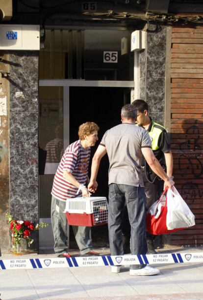 Dos vecinos del inmueble incendiado abandonan el edificio esta mañana.