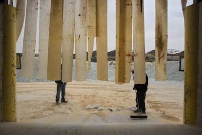 In this Sunday, Jan. 24, 2016 photo, a worker sweeps sand used to manufacture glass bottles at the Phoenicia Glass Works Ltd. factory in the southern Israeli town of Yeruham. Phoenicia Glass Works Ltd. produces a million bottles and containers a day for beverage giants Coca Cola, Pepsi, and Heineken, as well as Israeli wineries and olive oil companies. Every day, about 300,000 bottles come out of the ovens with defects. (AP Photo/Oded Balilty)