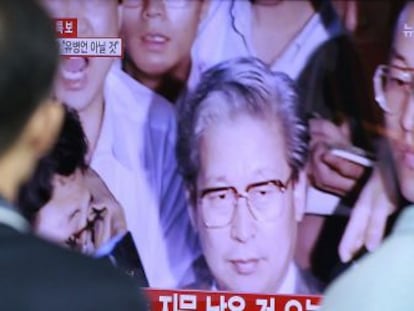 Dos personas siguen la noticia de la muerte de Yoo Byung-eun, dueño del 'Sewol'.
