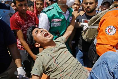 Personal de emergencias trasladan a un herido durante los enfrentamientos con las fuerzas de seguridad israelíes en la frontera entre Gaza e Israel, el 14 de mayo de 2018.