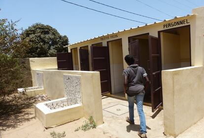 La alumna Ndeye Astau, de 13 años, se dispone a entrar en los baños de su escuela en Mbour. 