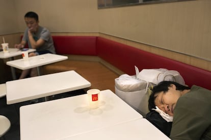 El fotógrafo Vincent Yu ha recorrido algunos de los McDonald´s en Hong Kong para mostrar la situación que viven los sin techo. En la imagen, una mujer duerme en uno de los establecimientos.