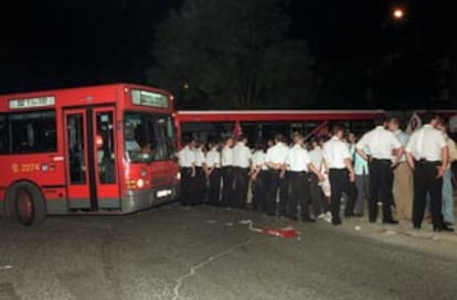 Agentes de la policia tratan de desalojar a los piquetes que impedían la salida de los autobuses de la Empresa Municipal de Transportes en Madrid.