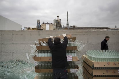 In this Wednesday, Jan. 27, 2016 photo, workers unload defective glass bottles to be recycled at the Phoenicia Glass Works Ltd. factory in the southern Israeli town of Yeruham. Factory workers grind these rejects into shards and pile them outside. Recycled glass bottles from across the country are sent here and ground up, too. The glass pieces are shoveled into the ovens to be fired into new glass bottles. Sand, the basic ingredient of glass, is hauled in from a nearby desert quarry. (AP Photo/Oded Balilty)