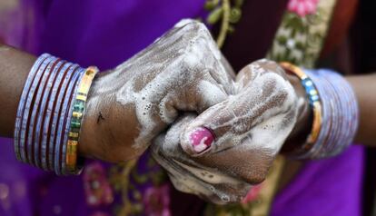 Una mujer lava sus manos con jabón en India. 