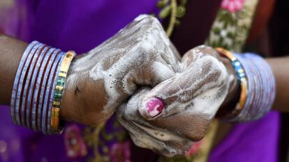 Una mujer lava sus manos con jabón en India. 