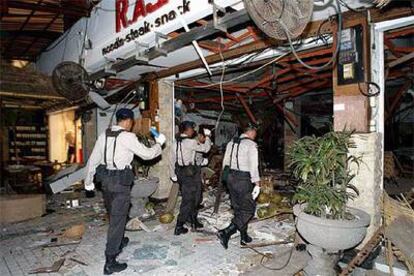 Policías indonesios inspeccionan uno de los restaurantes en los que se colocó una bomba ayer en la ciudad de Kuta, en la isla indonesia de Bali.