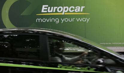 Un conductor pasa junto a un cartel de Europcar en Par&iacute;s.