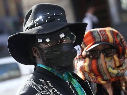 Una pareja luce máscaras sanitarias faciales para protegerse del coronavirus, en un desfile de Dolce & Gabbana.