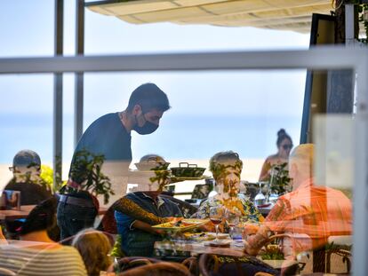 Un camarero sirve a unos clientes de una mesa de un restaurante del Paseo Marítimo de Platja d'Aro.