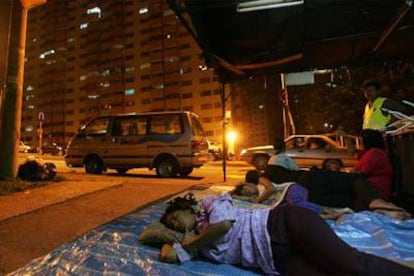 Una familia duerme en la calle en Kuala Lumpur después del terremoto.