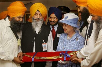 La reina de Inglaterra, Isabel II, recibe una espada ceremonial como regalo al final de su visita al templo Sij de Gurdhwara, en Leicester (Reino Unido). el 1 de agosto de 2002