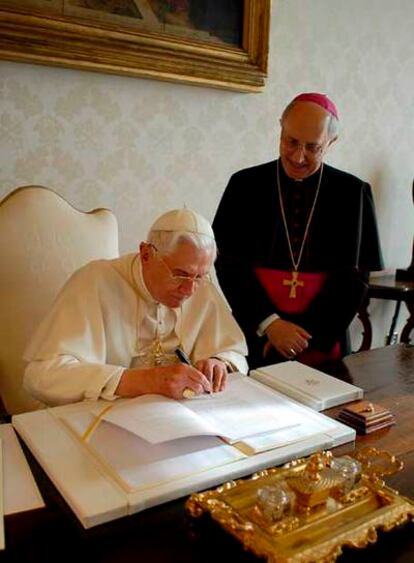 El Papa firma la encíclica<i> Spe salvi </i>ante el arzobispo Fernando Filloni.