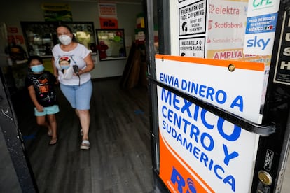 Una mujer sale de una tienda que ofrece servicios para enviar remesas a México y Centroamérica