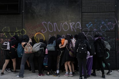 Un grupo de mujeres intervienen las bardas con consignas y pintas alusivas al 8M.