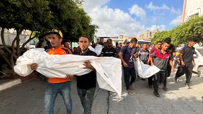Varios palestinos trasladan los cuerpos de familiares muertos en un ataque israelí, en Jan Younis, en Gaza.