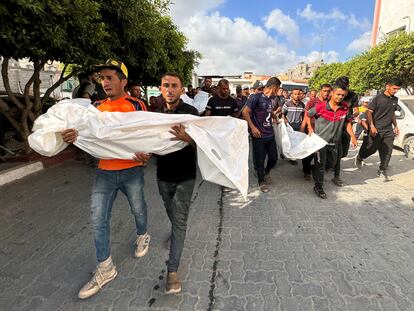 Varios palestinos trasladan los cuerpos de familiares muertos en un ataque israelí, en Jan Younis, en Gaza.