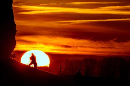 Un fot&oacute;grafo retrata la puesta de sol tras las monta&ntilde;as de Jura en la regi&oacute;n de Gros-de-Vaud, en Daillens (Suiza).  