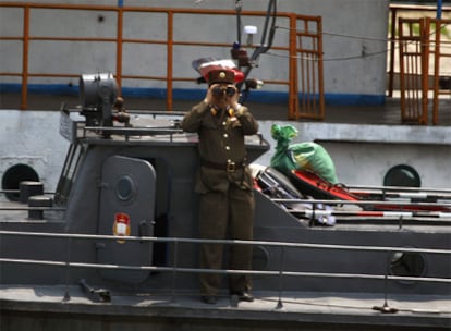 Un militar norcoreano vigila el paso de un barco chino en el río Yalu.