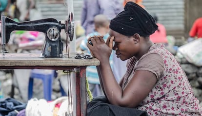 Una costurera del mercado de Majengo, en Goma, mira su teléfono móvil ante la falta de clientes.