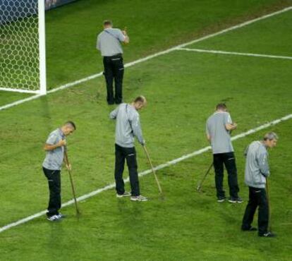 Operarios cuidan el césped en el descanso del Suiza-Francia.