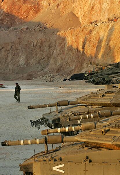 Un soldado israelí pasa por delante de una fila de tanques cerca de la frontera con Líbano.