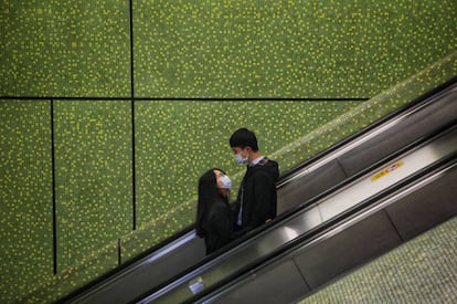 Una pareja vive su amor en tiempos ce coronovirus en un centro comercial de Hong Kong.