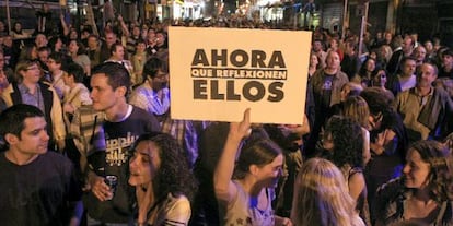 Una joven exhibe un cartel en una calle adyacente a Sol, durante el 15-M.