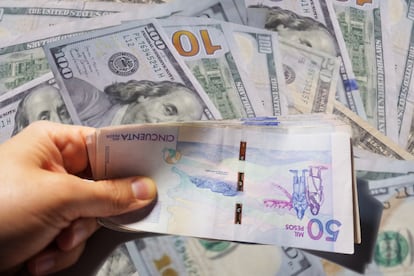 Una persona sostiene dinero colombiano.