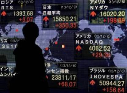Un empresario pasa por delante de una pantalla con la cotización de la Bolsa de Tokio.