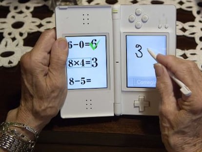Una persona mayor juega a la aplicaci&oacute;n Brain training en la consola Nintendo DS.