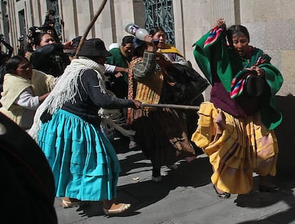 Esposas y policías amotinados se enfrentan a una indígena aimara fiel al presidente de Bolivia, Evo Morales.