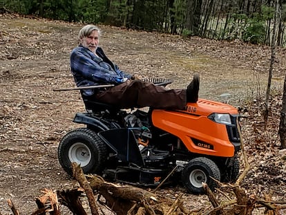 In this photo provided by Ed Smith, Geoffrey Holt rests his leg on top of his riding mower in Hinsdale, N.H., on April 4, 2020.