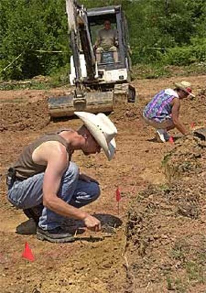 Inspectores de la Comisión de Desaparecidos buscan pruebas en la fosa.