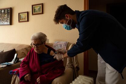 Un enfermero del CAP La Marina de Barcelona administra a domicilio la primera dosis de la vacuna a una mujer mayor de 80 años.