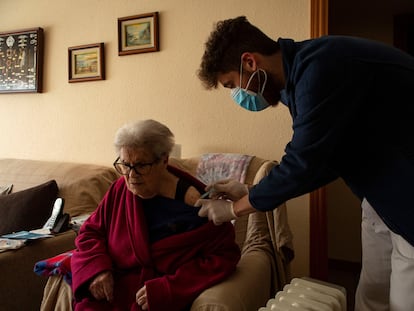 Un enfermero del CAP La Marina de Barcelona administra a domicilio la primera dosis de la vacuna a una mujer mayor de 80 años.