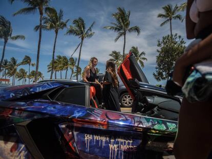 Dos jóvenes, junto a un coche deportivo en Miami Beach.