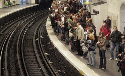 Viajeros esperan la llega de un convoy en una estación de Metro de París.