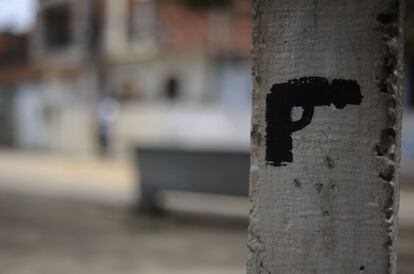 Una pistola pintada en el palo de una cruz es una amenaza a la policía brasileña para evitar que entre en Amaralina, una de las barriadas más conflictivas de Salvador de Bahía.