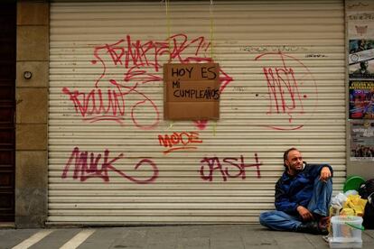 Un vagabundo pide dinero anunciando que es su cumpleaños en una calle de Pamplona.